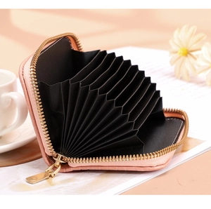 Detail of pink faux crocodile leather card holder with gold zipper and multi-slot interior