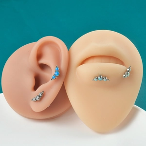 Detailed display of G23 titanium opal labret studs and cartilage earrings on a skin model