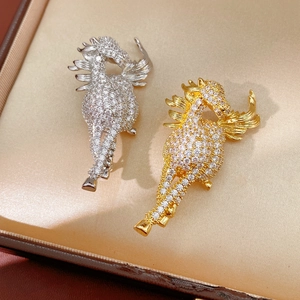 Detailed macro view of gold and silver horse brooches with micro-pave cubic zirconia crystals