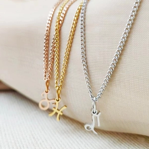 Macro detail of zodiac pendants in gold, rose gold, and silver on textured fabric