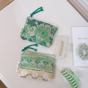 Floral jacquard mini coin purses in green and gold silk fabric with knotted zipper pulls