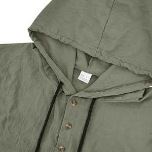 Detail view of olive linen hoodie shirt featuring buttoned neckline and textured fabric
