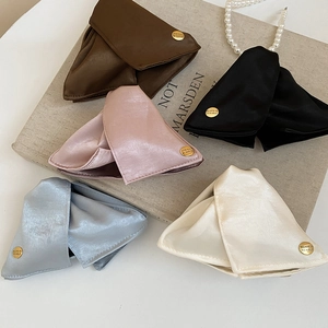 Satin and PU leather triangle hair claws in five colors on a vintage book