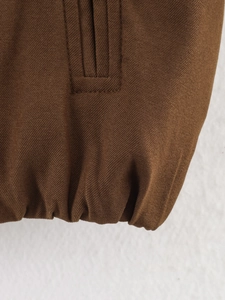 Gros plan sur un tissu sergé marron montrant les coutures d'ourlet et la texture textile