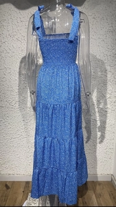 Detail view of tiered hem and open back on a blue polka dot summer maxi dress