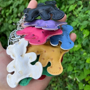 Close-up of colorful PU leather bear pendants with metal keyrings and grainy textures