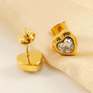 Elegant gold heart earrings with sparkling zircon on premium pleated silk background