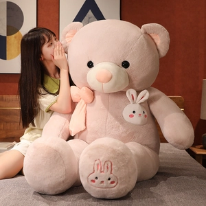 Detail of pink giant teddy bear with silk bow and bunny embroidery on the foot