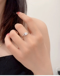 Close-up of elegant 0.5ct moissanite silver ring worn on model hand with wavy band