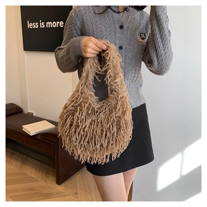 Detail of soft khaki faux fur handbag held by model in stylish autumn knitwear