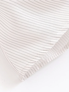 Macro shot of vertical black stripes on white fabric with detailed stitching and hem work