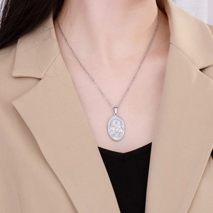 Detail of silver oval necklace with relief of Virgin and Child on professional model