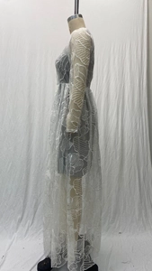 Detail of floral lace embroidery and sheer mesh layers on white formal long sleeve dress