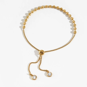 Verstellbares goldenes Perlenarmband aus Edelstahl mit runden Zirkonia-Anhängern auf Weiß