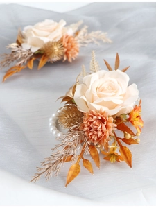 Détail d'un corsage de poignet rose crème avec bracelet en perles et feuilles dorées