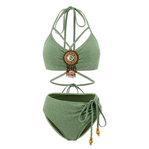 Detail of green bikini top with bohemian colorful beads, fringe, and textured fabric
