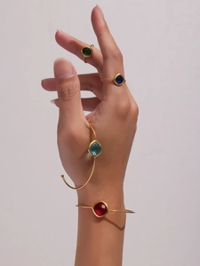 Close-up of elegant gold plated bracelets and rings with colorful Czech glass gemstones