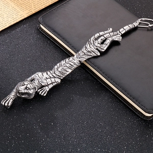 Detailed close-up of tiger-shaped steel charm on a leather notebook with a vintage finish