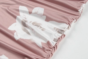 Detail of floral printed fabric with elastic smocking and soft pink and white texture