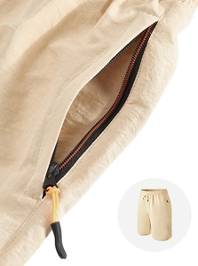 Close-up of side zipper pocket with orange pull on khaki quick-dry athletic shorts