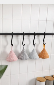 Hanging fabric triangular pot handle covers in floral, leaf, and checkered patterns