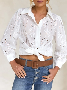 Detail of white hollow embroidery shirt with puff sleeves and casual waist-tie styling