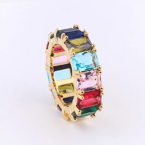 Macro detail of gold eternity ring featuring multi-colored baguette-cut cubic zirconia