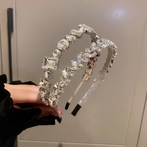 Close-up of sparkling rhinestone headbands with geometric crystal patterns on silver metal