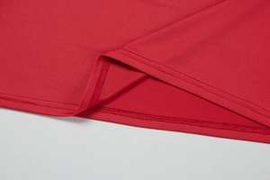 Close-up of red knit dress hemline showing high-quality double-needle flat stitching