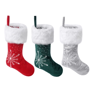 Three velvet Christmas stockings with snowflake embroidery in red, green and silver colors
