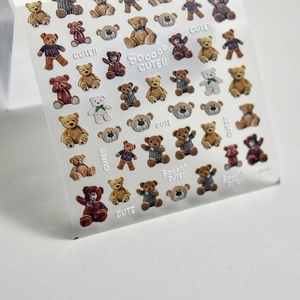 Detailed view of cute teddy bear embossed nail stickers with British flag sweater designs