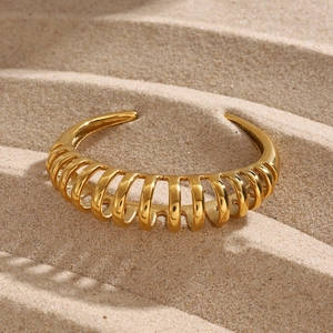 Macro shot of gold-plated stainless steel cuff bracelet with spiral ribbed texture
