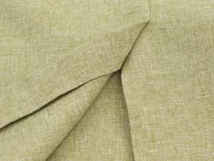 Close-up of light green linen fabric showing natural texture and stitching detail