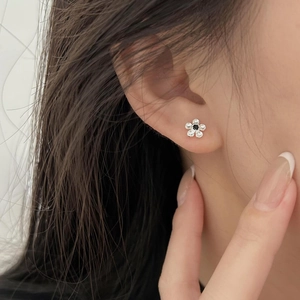 Macro view of 925 sterling silver flower stud earring with black and clear stones