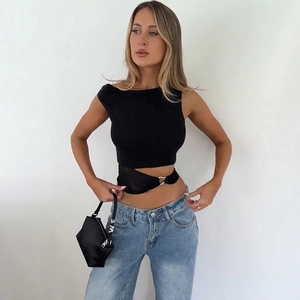 Dettaglio del crop top nero con taglio irregolare e accento elegante con anello metallico