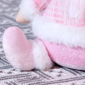 Detail of pink knitted fabric and white faux fur textures on Christmas plush doll