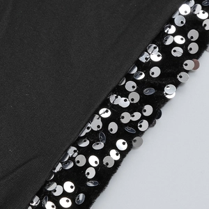 Macro detail of black ribbed fabric with silver sequins on velvet trim for party dress