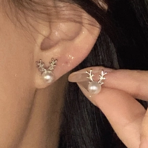 Detail of elegant silver reindeer antler stud earrings with pearls for Christmas