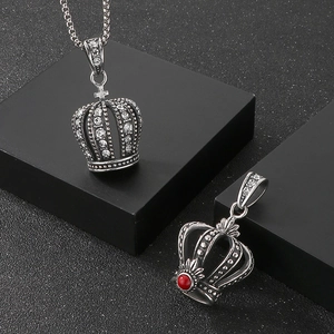 Macro detail of punk hip hop crown pendants with rhinestones and vintage silver finish