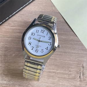 Detail of quartz watch 3205 with stretch steel band on a wooden background