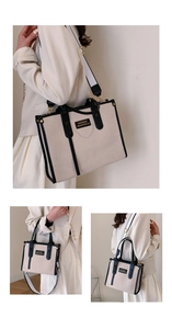 Detail of canvas tote bag with contrast leather handles and wide bicolored shoulder strap
