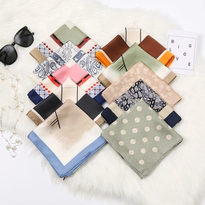 Variety of paisley and geometric print silk scarves displayed on a soft white fur background