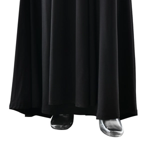 Dettaglio dell'orlo del vestito nero elegante con tessuto drappeggiato e tacchi argento
