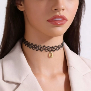 Close-up of a handmade black fishline choker necklace with a gold Q letter pendant.