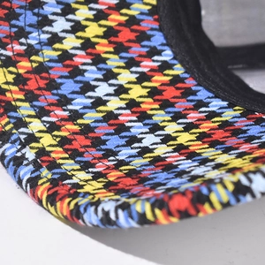 Macro view of plaid pattern fabric and black hemmed edge on baseball cap brim