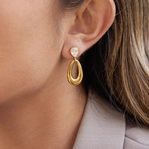 Nahaufnahme von goldenen Edelstahl-Ohrringen mit birnenförmigem Zirkon am Modell