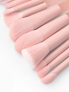 Close-up of soft peach pink makeup brushes with dense bristles and smooth handles