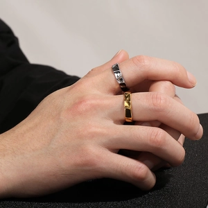 Detailed view of gold and silver stainless steel rings with irregular geometric textures