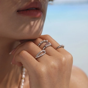 Elegant silver stackable rings set with pearls and diamonds for women on a beach setting