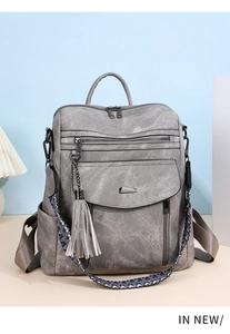 Detail view of grey PU leather backpack with vintage fringe and plaid woven straps